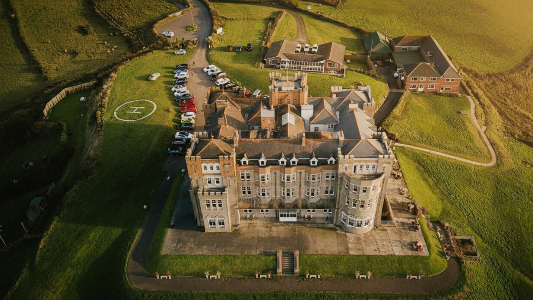 Aerial view of Camelot Castle Hotel in Tintagel, set in green countryside on the North Cornwall coast