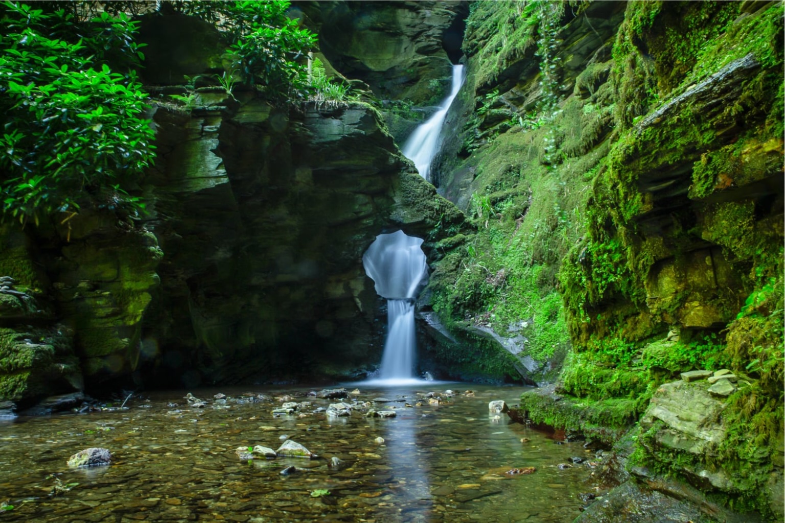 St Nectans Glen waterfall near Tintagel in North Cornwall surrounded by moss-covered rocks